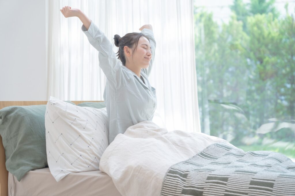 起床して伸びをする女性