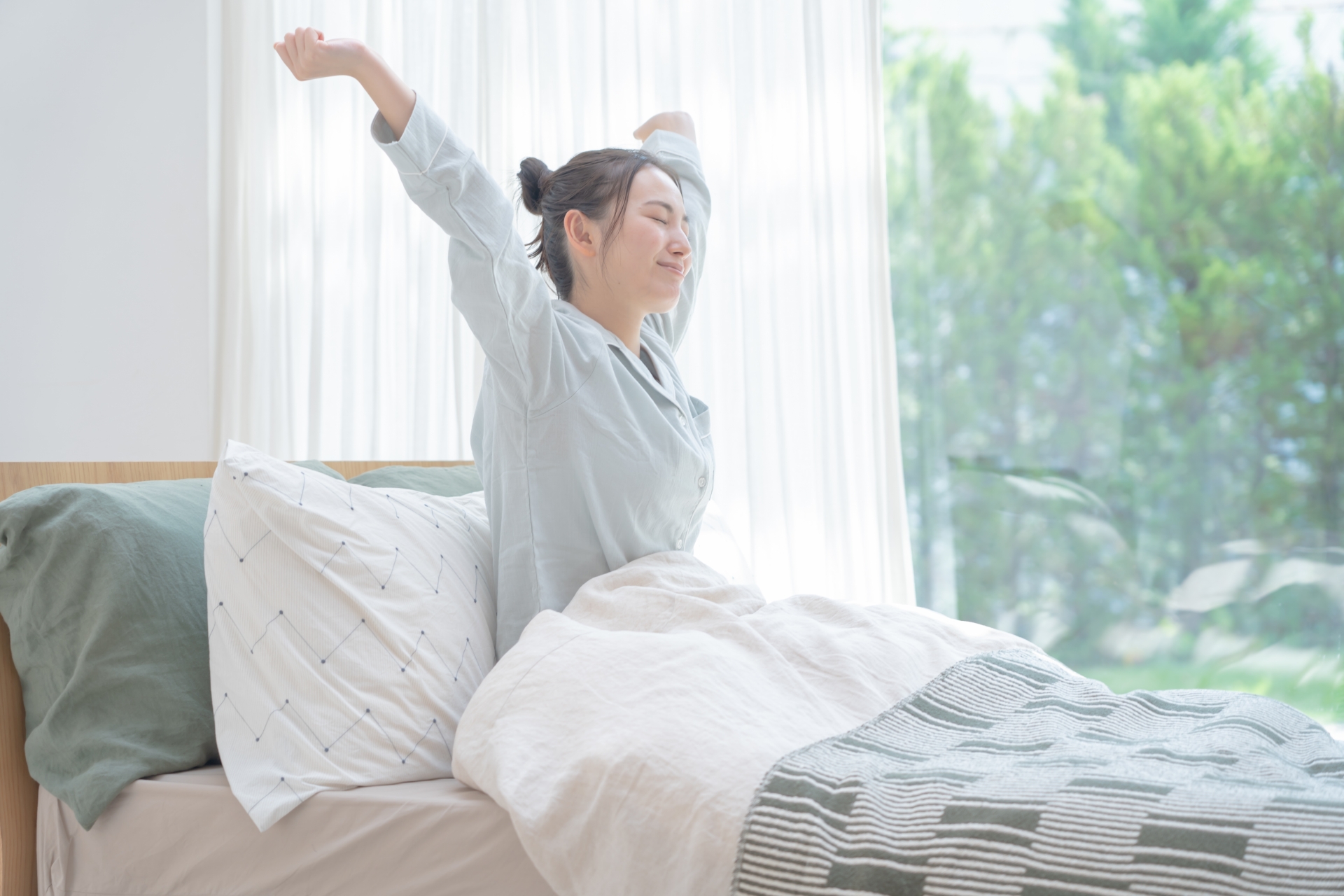 起床して伸びをする女性